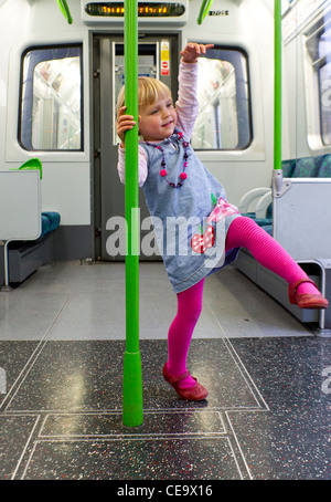 Little girl dancing in the carriage of a train Stock Photo