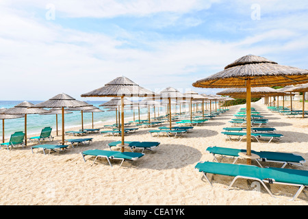 Rows of umbrellas on empty seaside beach in Greece Stock Photo
