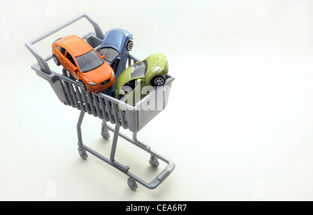 MODEL CARS IN SUPERMARKET SHOPPING TROLLEY RE CAR BUYING BUYERS INTERNET INSURANCE RISING PRICES MOTORING SHOPPING DRIVERS UK Stock Photo