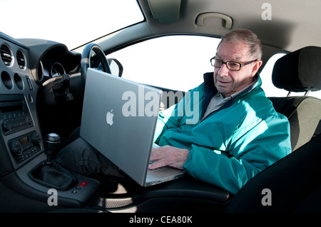 senior man using laptop computer in car Stock Photo