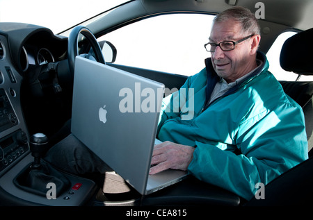 senior man using laptop computer in car Stock Photo