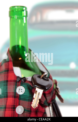bottle dressed in jacket warmer with keys and alcohol with a car in background depicting drunk driving and addictions can kill Stock Photo