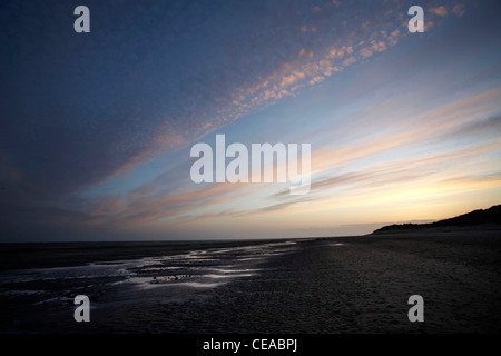 The sun setting over a beach in Barmouth Stock Photo