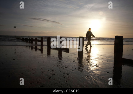 Silhouette of person on the beach in Barmouth during sunset. Stock Photo