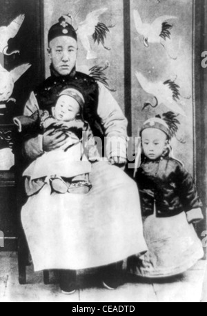 Three year old Emperor of China, Puyi, right, with his father, Prince Chun, the Regent, holding a younger brother. Stock Photo