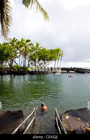 Bathers enjoy a soothing soak at this hot pond at Kapoho Point on Big Island's volcanic eastern coastline, Hawaii Stock Photo