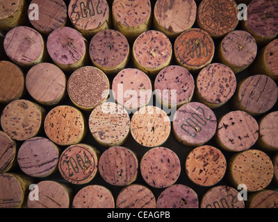 A collection of used wine corks, several with the vintage year visible. Stock Photo