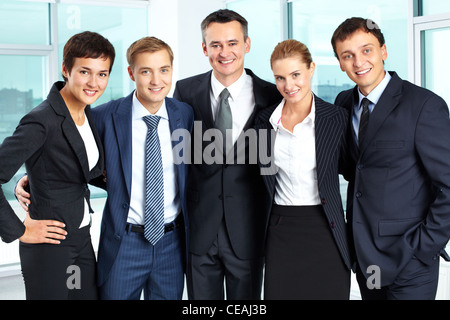 Business team of people embracing each other on the background of sky