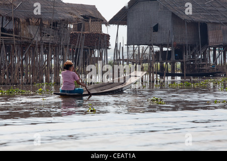 Tribal people on Inle lake are daily paddling their floating boats from place to place as the only one transport source. Stock Photo