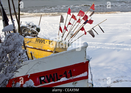 Fishing boats RWL-11 and RWL-15 on a snow-covered beach in Rewal, Poland. Winter by the sea. Stock Photo