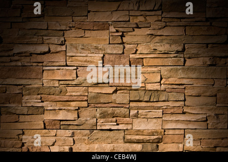 Irregular sized brown bricks with an organic feel, lit dramtically from above Stock Photo