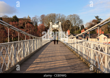 View along Queens Park Bridge 1923 suspension footbridge across the River Dee with people crossing. Chester Cheshire England UK Britain Stock Photo