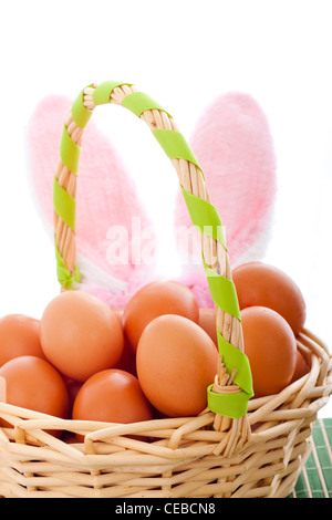 Detail of Easter basket with eggs and bunny ears, isolated on white background. Stock Photo