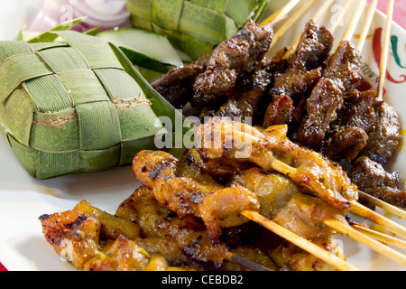 Chicken and Lamb Satay Skewers with Ketupat Rice Wrapped in Coconut Leaf Stock Photo