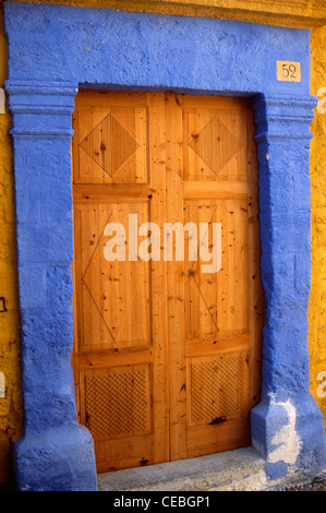 wooden doorway with a deep blue stone surround on the Greek island of Rhodes. Stock Photo