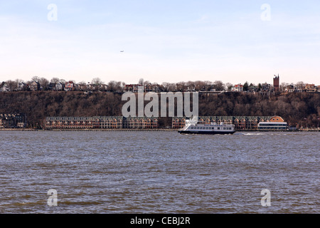 A view of the New Jersey shoreline with a ferry passing, shot from the Intrepid Sea, Air & Space museum in New York, NY. Stock Photo