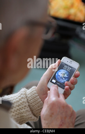 elderly older man adopting using enjoying new technology, iPhone 4S, Smartphone, intuitive touchscreen at home Stock Photo