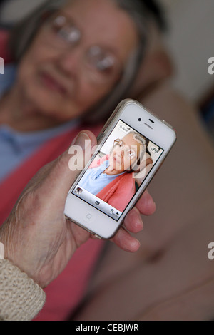 Elderly woman browsing old photographs at a village history open day ...