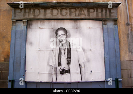 A photographer's studio window with a poster of a man with a camera on a strap, Toulouse, Haute-Garonne, Midi- Pyrenées, France. photographer Stock Photo