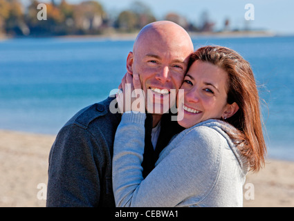 Handsome young couple hugging at the beach in winter Stock Photo