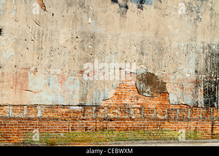 A weathered, grungy, dirty, cement covered brick wall in a city back alley. Lots of options and possibilities for the designer! Stock Photo