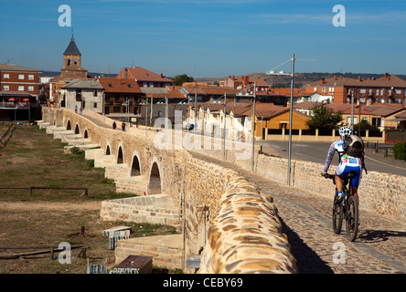 Cyclist on the Camino de Santiago through the town of Hospital de Orbigo Stock Photo