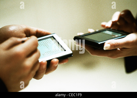 Two people exchanging information using personal digital assistants Stock Photo