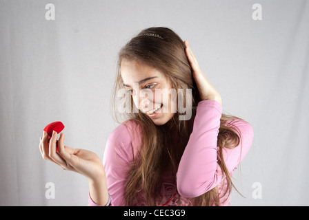 Teenage girl in pink surprised with plush heart gift Stock Photo
