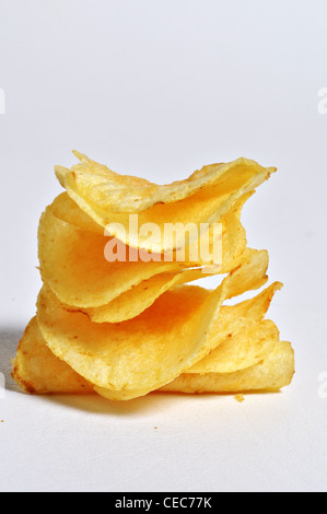 A stack of potato chips sits on a plain white background. Stock Photo