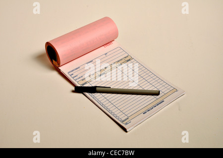 A open receipt book and pen are laying on a table. Stock Photo