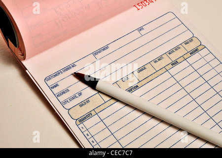 A open receipt book and pen are laying on a table. Stock Photo