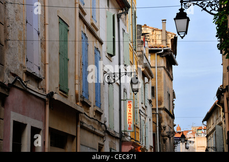 Traditional Arles street with street lamps, coloured shutters and patisserie sign