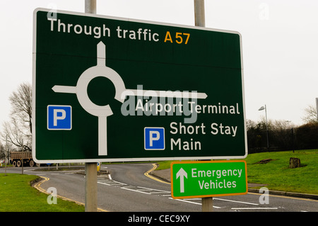 Road sign at an airport showing through traffic, terminal and parking Stock Photo