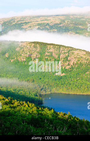 Morning fog hugs the summit of Sargent Mountain above Eagle Lake in Maine's Acadia National Park, from Cadillac Mountain. Stock Photo