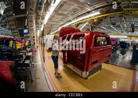 A woman factory worker checks newly installed door hardware on an F-150 pickup truck at the Ford final assembly plant Stock Photo