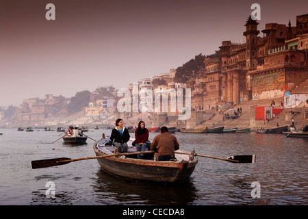 India, Uttar Pradesh, Varanasi, Munshi Ghat, tourists enjoying dawn rowing boat view of ghats in first light Stock Photo