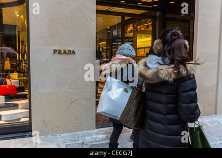 Paris, France, Women Walking on Street ,Luxury Window Shopping on 'Rue Faubourg Saint Honoré', Prada Shop Front WIndow, SIgn, woman with shop bags outside shops Stock Photo