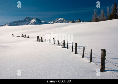 Barbed Wire fence covered with snow in an Idaho mountain scene Stock Photo