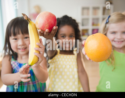 Children holding out fresh fruit Stock Photo
