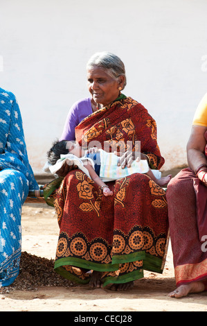 Indian grandmother holding a new born baby in a rural indian village. Andhra Pradesh, India Stock Photo