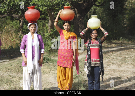 Indian woman  carrying water pots to fill from well ,Villagers have to fetch water from its natural sources. India Stock Photo