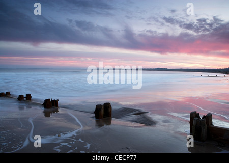 Twilight hues over wooden groynes on the beach at Alnmouth, Northumberland. Stock Photo