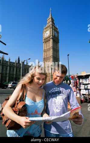 England, London, Young Tourist Couple looking at London Map in front of Big Ben Westminster Stock Photo