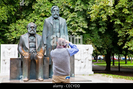 Tourist taking photo of Karl Marx & Friedrich Engels statue in Marx-Engels-Forum park in central Mitte district, Berlin, Germany Stock Photo