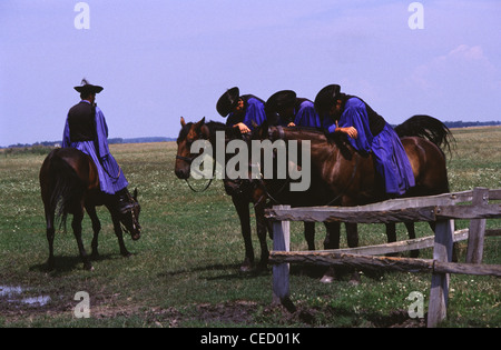 Csikos mounted horse-herdsmen in traditional attire sit on Nonius horse breed in the vast Hungarian Plain called the Puszta of Hortobagy National Park near Debrecen Eastern Hungary Stock Photo