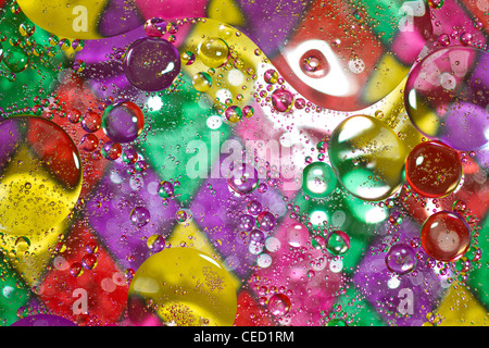 Harlequin pattern with abstract bubbles of oil, oil on water, clear oil with multi color harlequin pattern as background Stock Photo