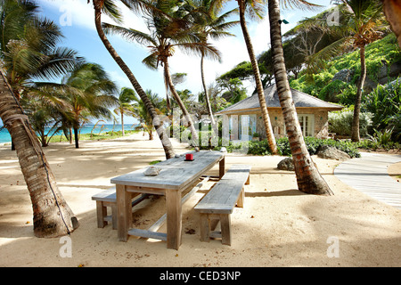 Island paradise beach private exclusive Mustique Caribbean palm trees secluded no people sky sand sea deserted sunny sunshine ocean hammock blue Stock Photo