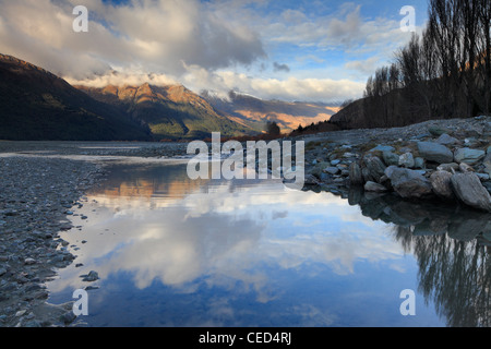 Snow-covered mountains reflected in an eddy of the Matukituki River in Mt Aspiring National Park Stock Photo