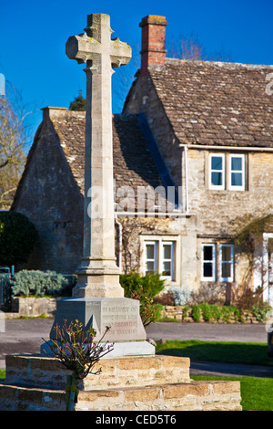 Stone war memorial on the green in the Cotswold village of Biddestone, Wiltshire, England, UK Stock Photo