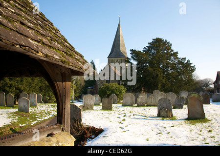 St James Church, Shere, Surrey on the banks of the River Tillingbourne on a snowy, sunny cloudless February day Stock Photo